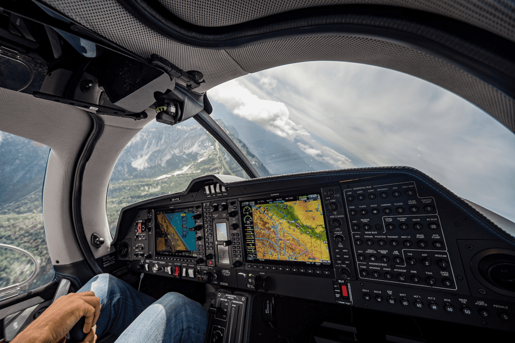 Airplane cockpit with pilot and navigation screens.