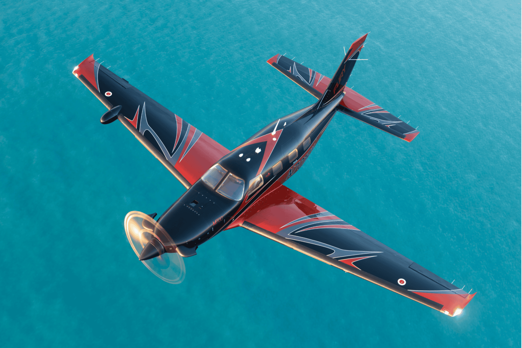 Black and red airplane flying over ocean.