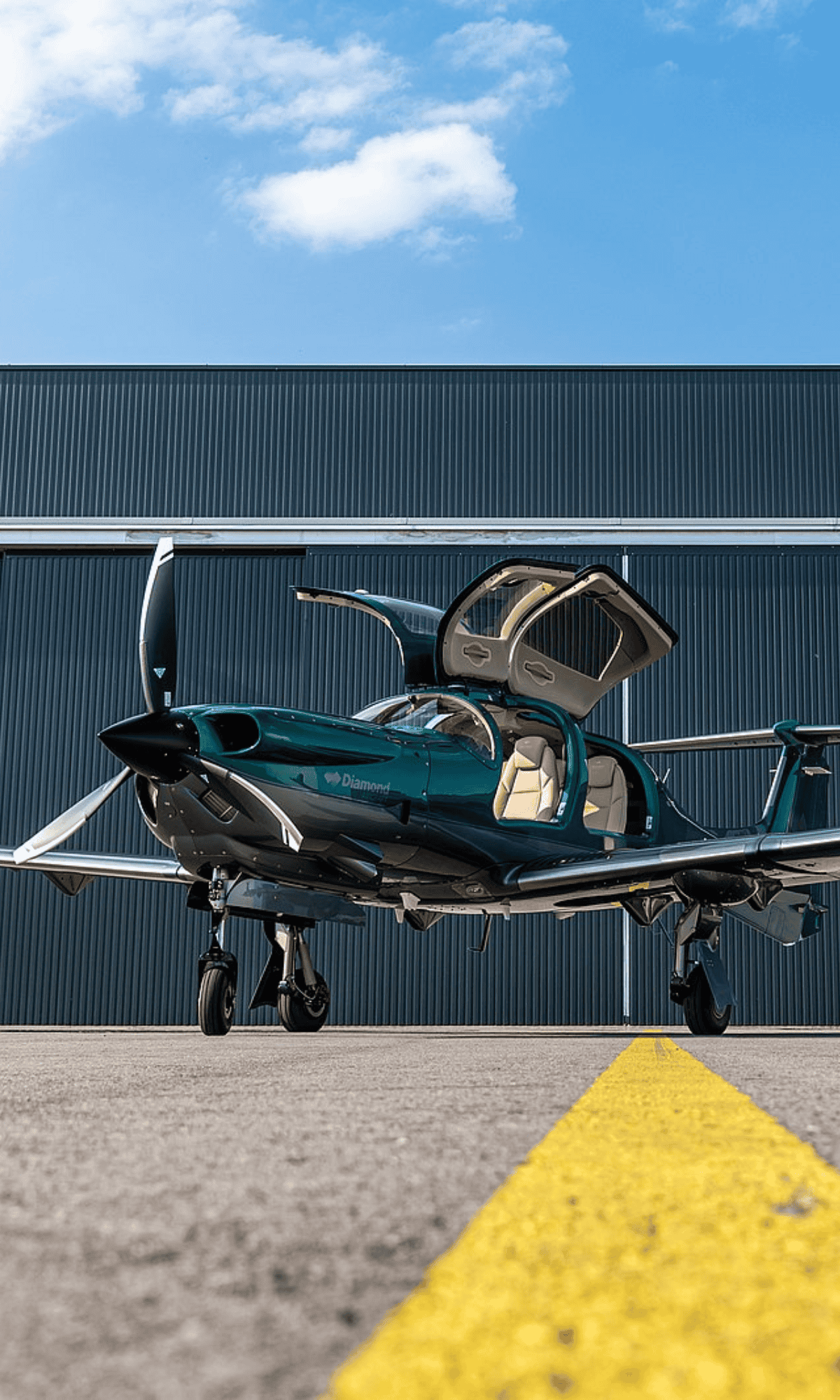 Small green airplane on runway with open doors.