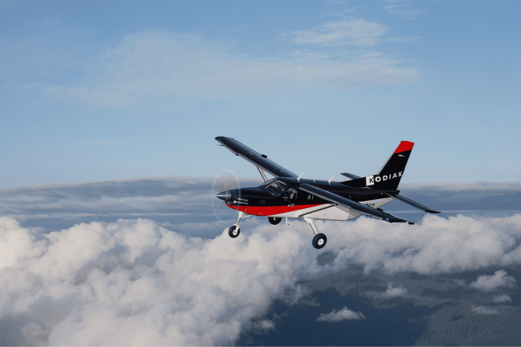 Kodiak airplane flying above clouds