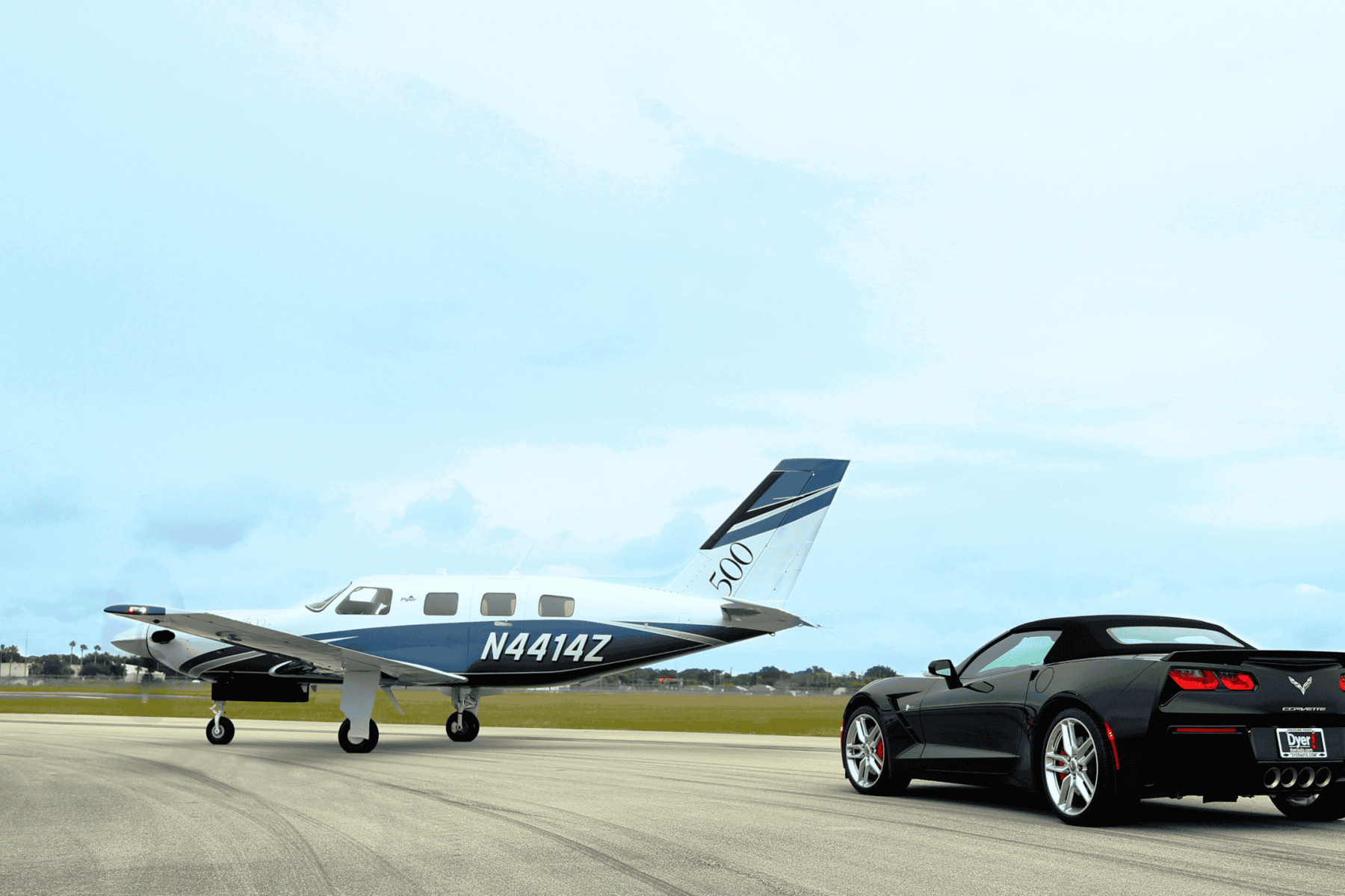 Black sports car and airplane on runway