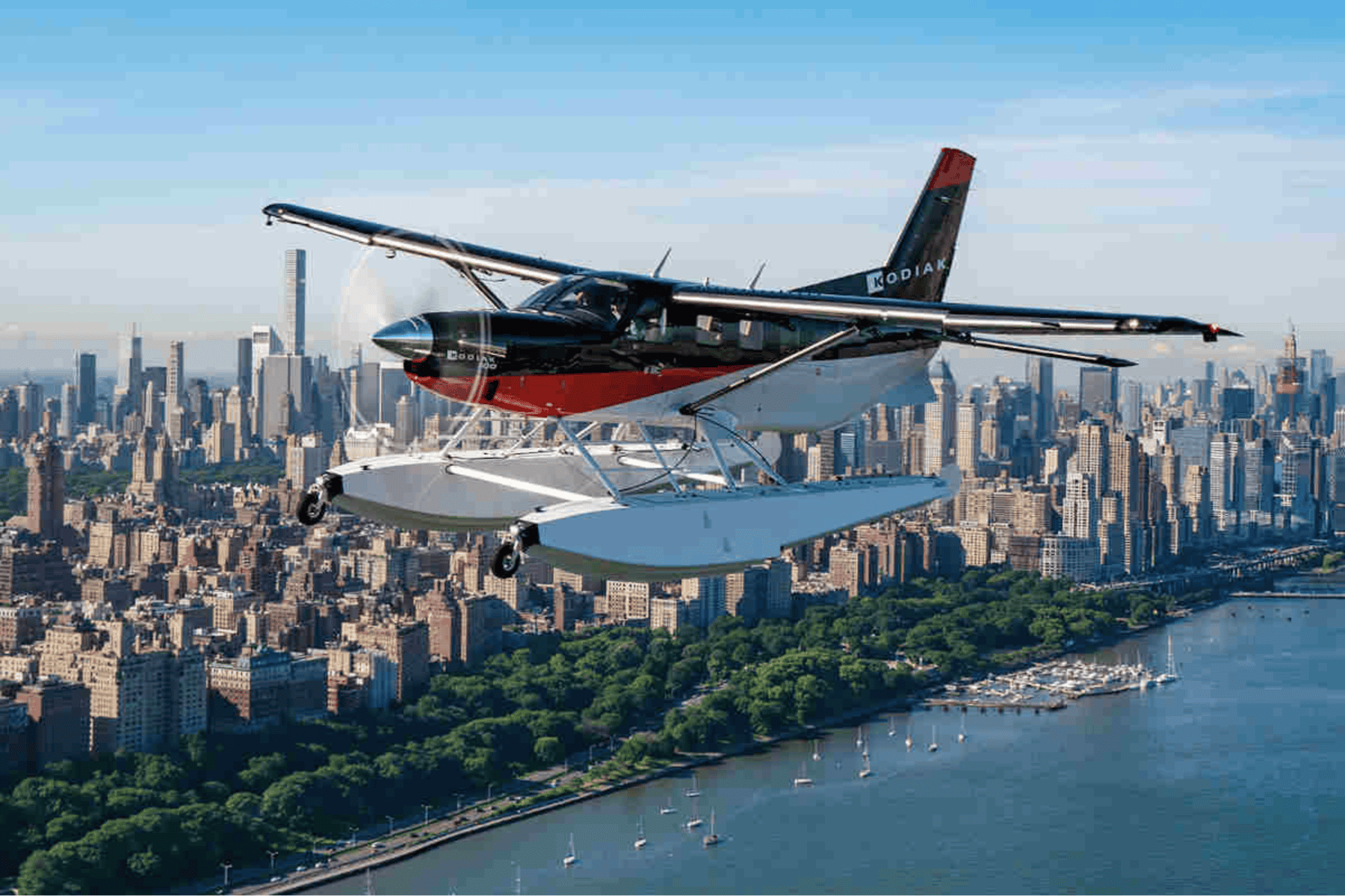 Seaplane flying over New York City skyline.