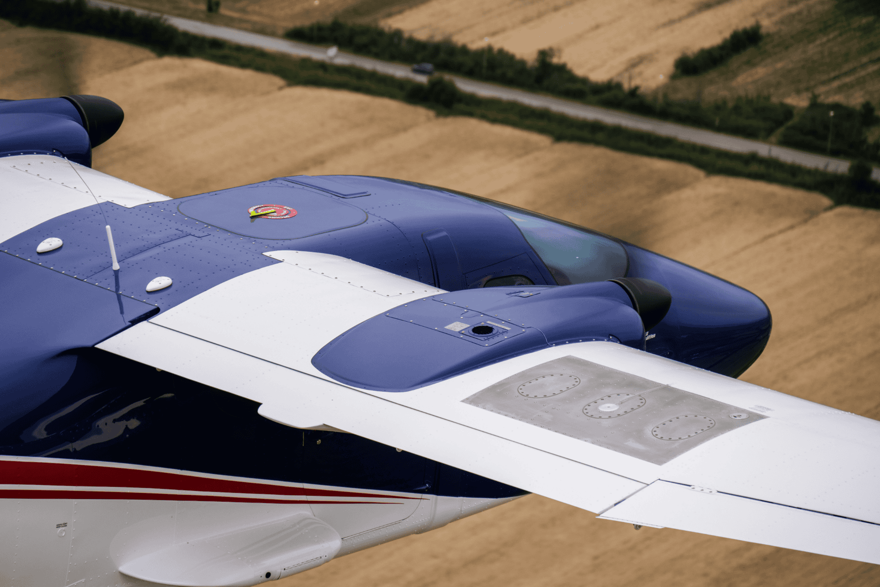 Blue and white airplane wing in flight.