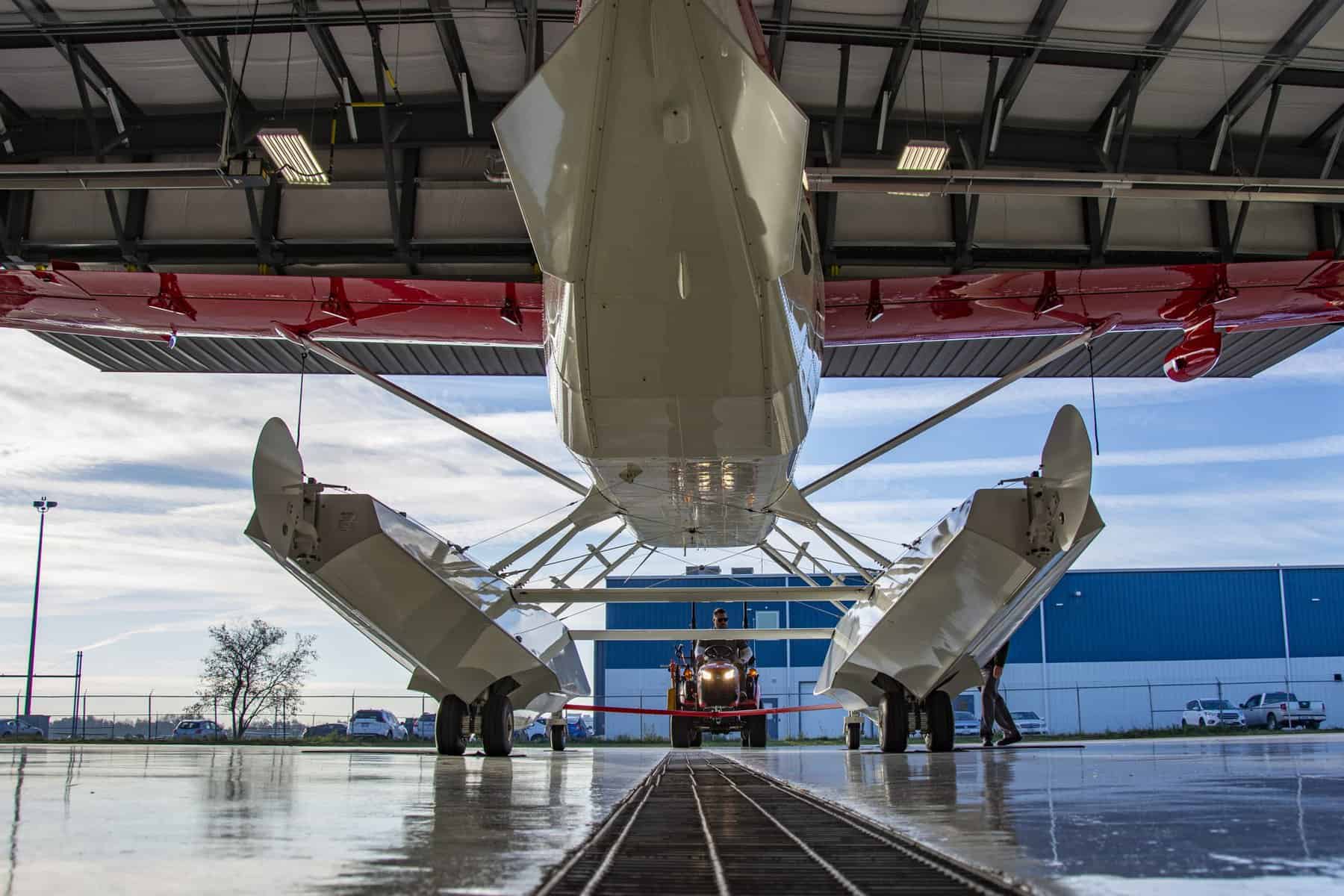Seaplane in hangar with blue sky background.