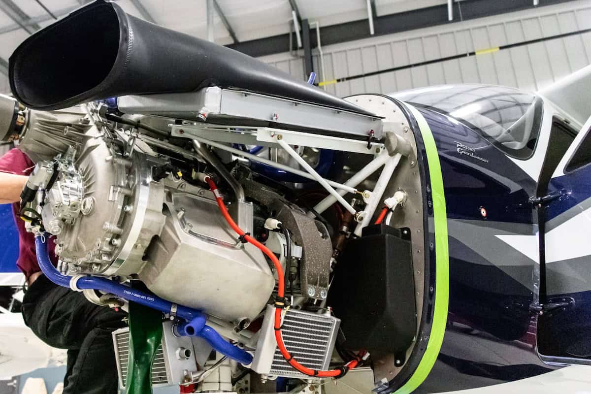 Blue and white Cessna airplane flying over water.