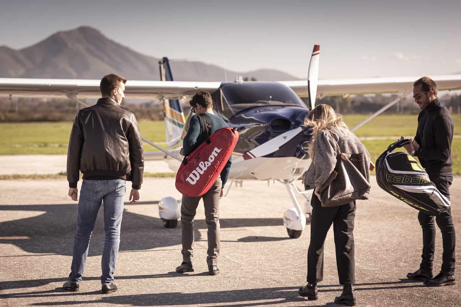 Two people standing beside a small airplane.
